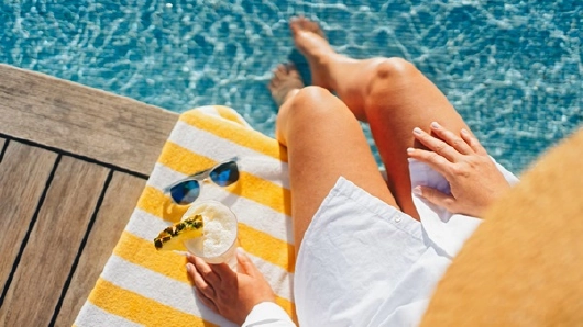 Frau am Pool mit Sonnenbrille