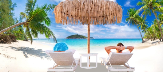 Karibischer Strand mit Menschen auf Sonnenliegen